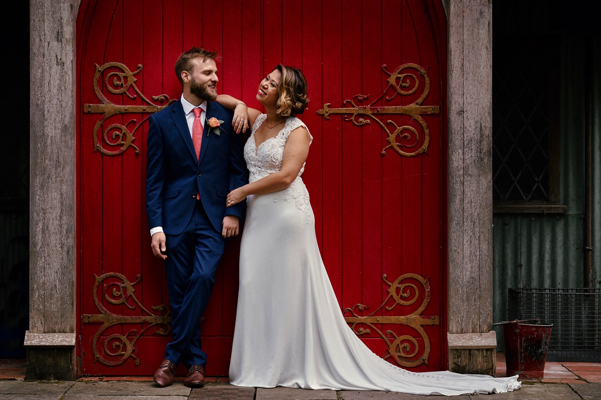 Bride and groom pose in the doorway of the tin tabernacle at Walcot Hall Hotel, Shropshire.